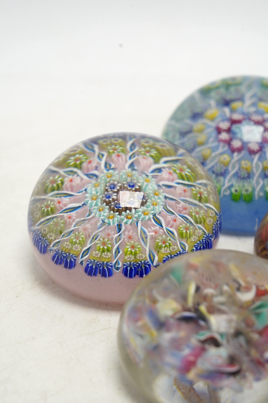 Two Perthshire millefiori glass paperweights and two scrambled glass paperweights, largest 7cm wide. Condition - fair